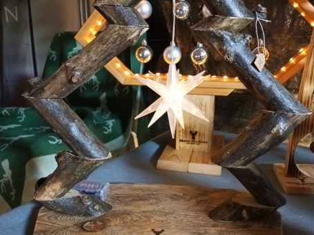 Holzbaum aus Ästen mit beleuchteten Stern